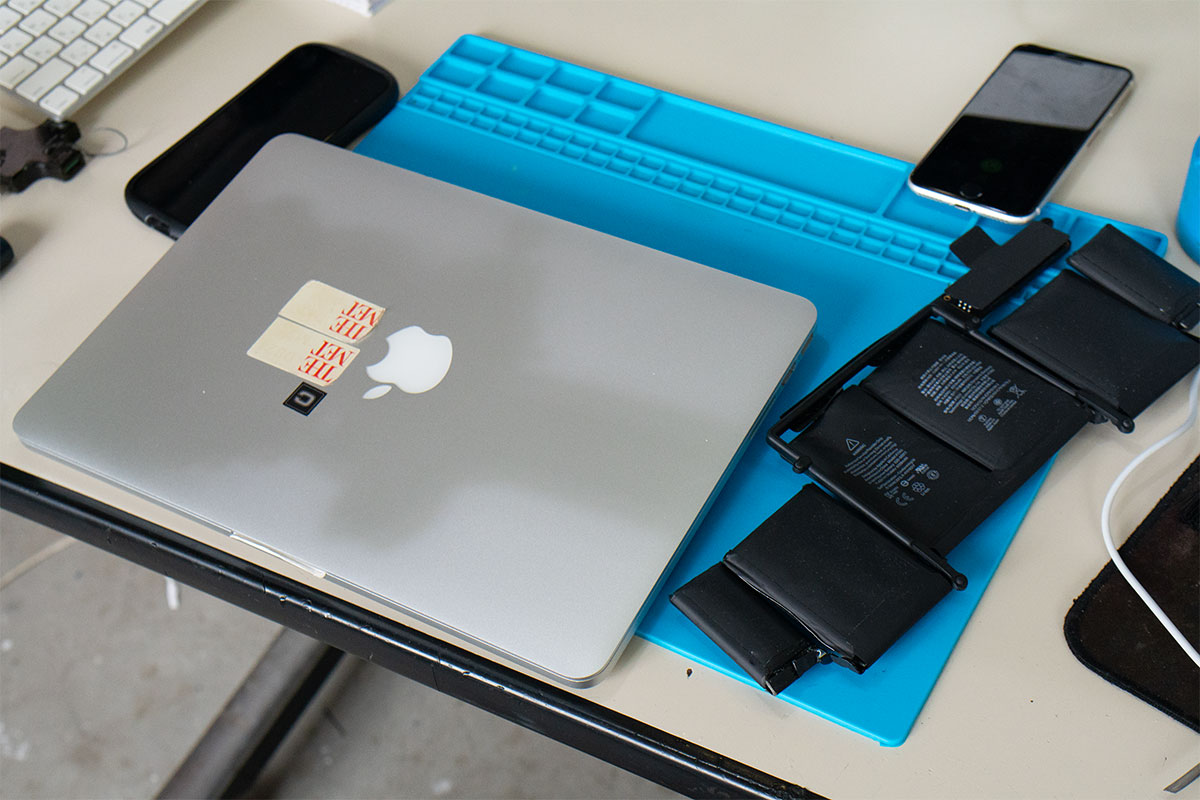 作業マットの上でMacBook Pro 2015を確認する修理作業